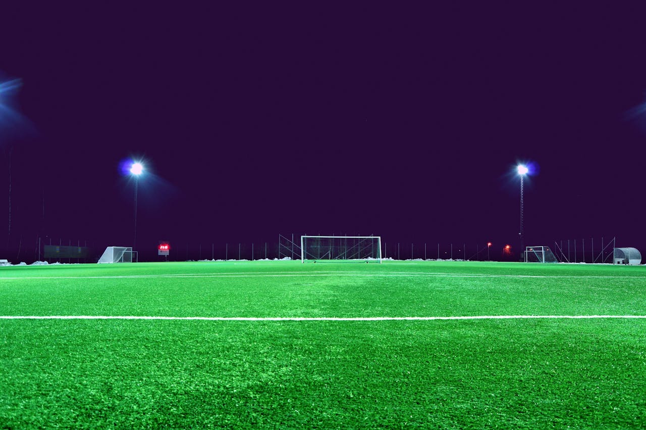 Services-02 A brightly lit soccer field at night in Norrtälje, Sweden, showcasing green turf and stadium lights.