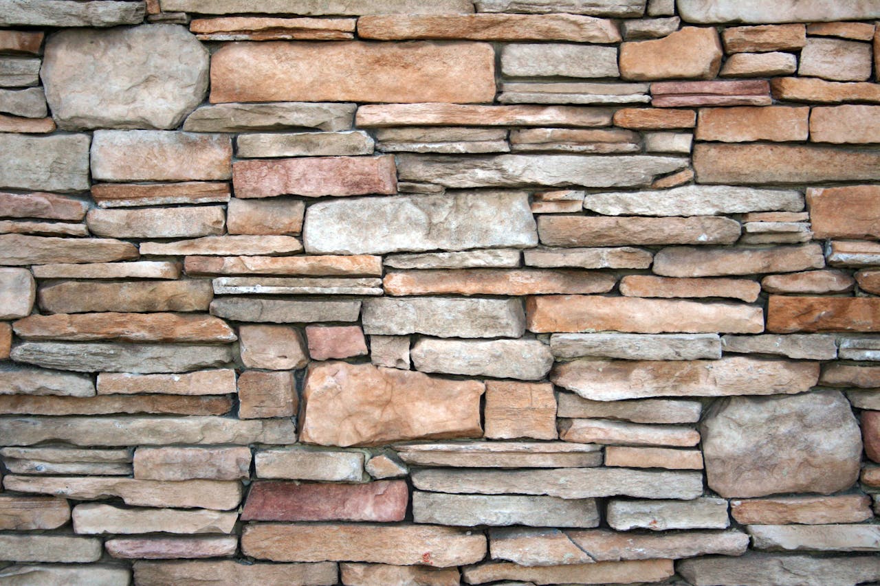 Services-03 High-resolution image of a natural stone wall with various textures and earthy tones.